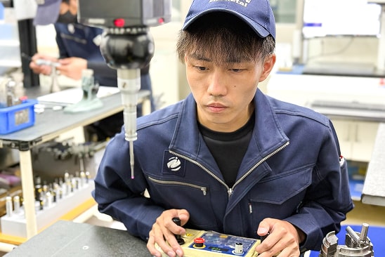 私は品質管理課で製品の寸法測定を担当しています。
三次元測定機やノギス、マイクロメーターといった測定機器を使い、製品が図面通りに正確に加工されているかを一つひとつ丁寧に確認しています。
わずかな不具合も見逃すことができない細かな作業が多い分責任も大きいですが、それだけに品質を支えるという誇りを持って仕事に取り組んでいます。
ときには難しさを感じることもありますが、日々の積み重ねを通じて自分の成長を実感できる点にやりがいを感じています。